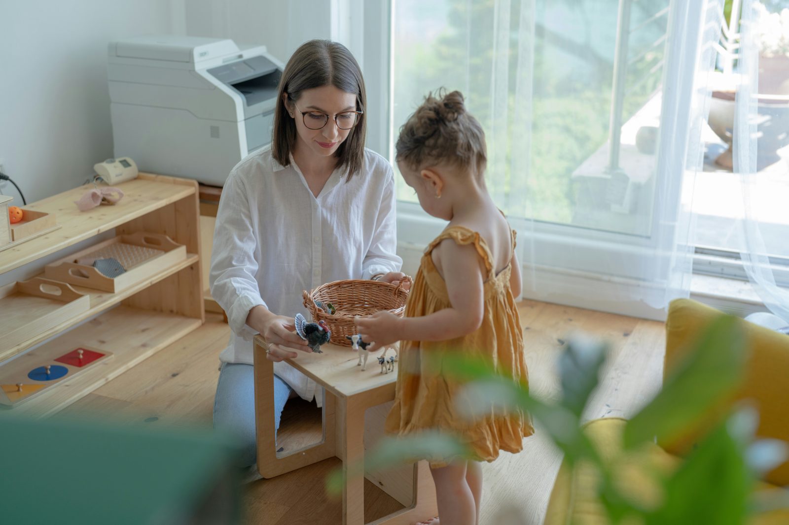 Parent and child playing with toys at a table