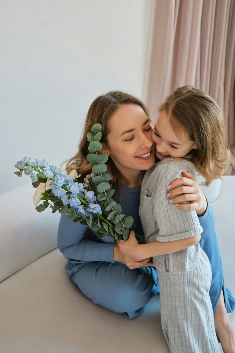 Mother and daughter sharing a hug with flowers